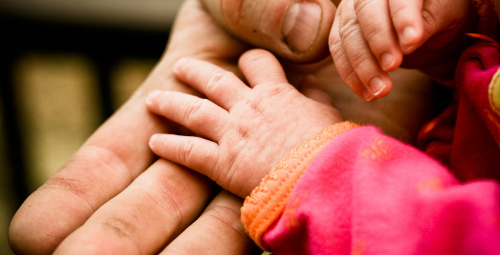 Parent and baby holding hands - flickr creative commons image by aaron gilson (flic.kr/p/9fWraA)